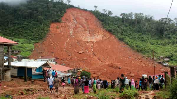 Image: People inspect the damage after a mudslide in the mountain town of Regent