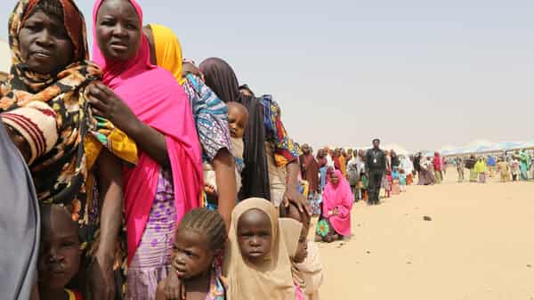 Families displaced by the Boko Haram insurgency line up for food