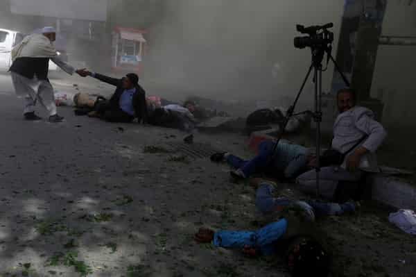 Afghan journalists are seen after a second blast in Kabul