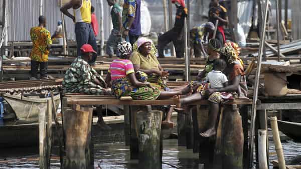 Residents sit outside their demolished stilt houses, after the metropolitan government begins the demolition of the Makoko riverine settlement on the Lagoon in Lagos