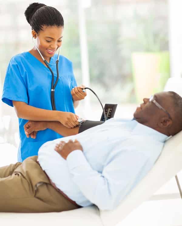 young african doctor checking senior patient’s blood pressure