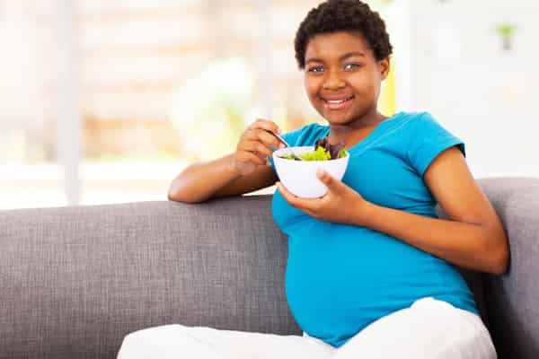 A pregnant woman eating. Photo Canstock