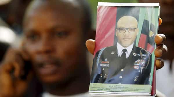 A supporter of Indigenous People of Biafra (IPOB) leader Nnamdi Kanu holds a photograph of Kanu, who is expected to appear at a magistrate court, during a rally in Abuja