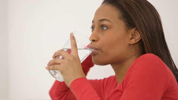 A woman drinking water Photo – Shutterstock