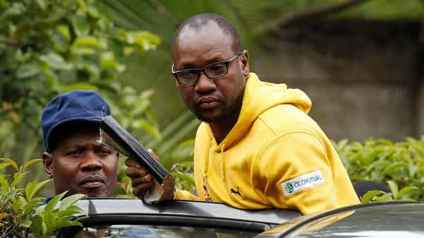 Activist Pastor Evan Mawarire is taken into a vehicle by police outside his home in Harare