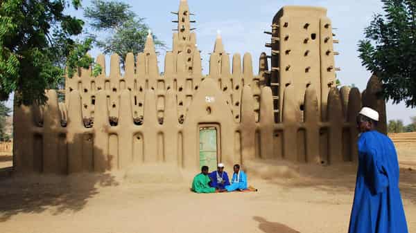 Muslim Dogons talk in front of a mud mosque in the village of Koni Komboro
