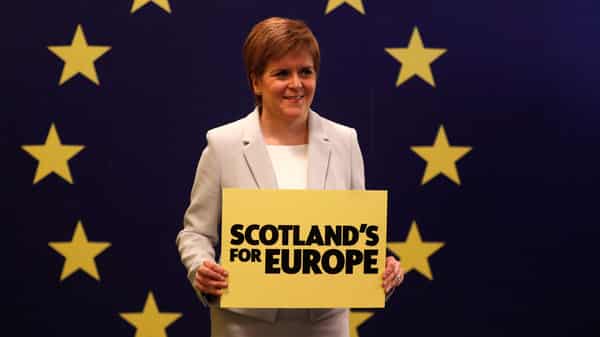 Scotland’s First Minister Nicola Sturgeon stands in front of a European Union flag at the Scottish National Party (SNP) conference in Edinburgh