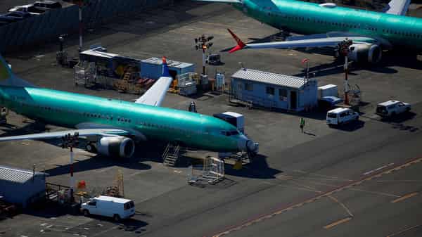 FILE PHOTO: A worker walks past unpainted Boeing 737 MAX aircraft parked at Renton Municipal Airport in Renton