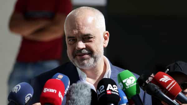 Albania’s Prime Minister Edi Rama speaks to the media as he arrives at the polling station near Tirana