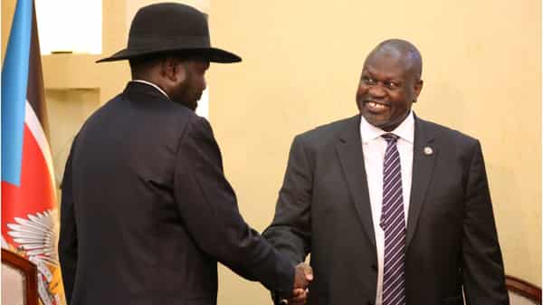 South Sudan’s President Salva Kiir Mayardit shakes hands with Riek Machar, ex-vice president and former rebel leader, during their meeting at the State House in Juba