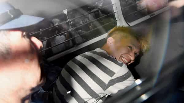 Satoshi Uematsu, suspected of a deadly attack at a facility for the disabled, is seen inside a police car as he is taken to prosecutors, at Tsukui police station in Sagamihara, Japan