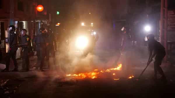Riot police try to put out fire in the middle of the street during protests in Dakar