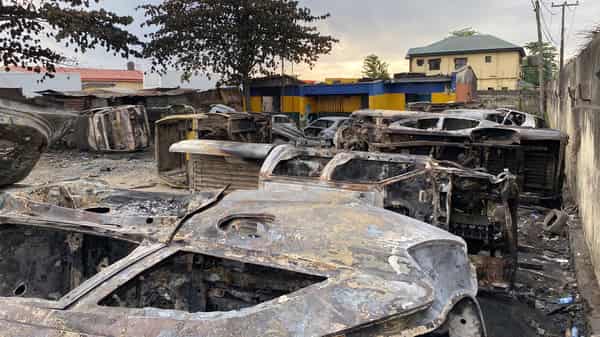 Burnt vehicles are pictured at a damaged police station in Lagos