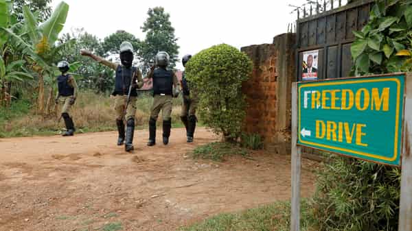 FILE PHOTO: Ugandan police officers order journalists to leave a road  leading to the home of Ugandan opposition presidential candidate Robert Kyagulanyi, also known as Bobi Wine, in Kampala