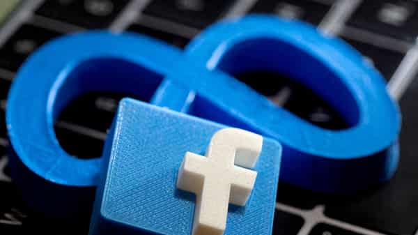 FILE PHOTO: 3D-printed images of the logos of Facebook and parent company Meta Platforms are seen on a laptop keyboard in this illustration