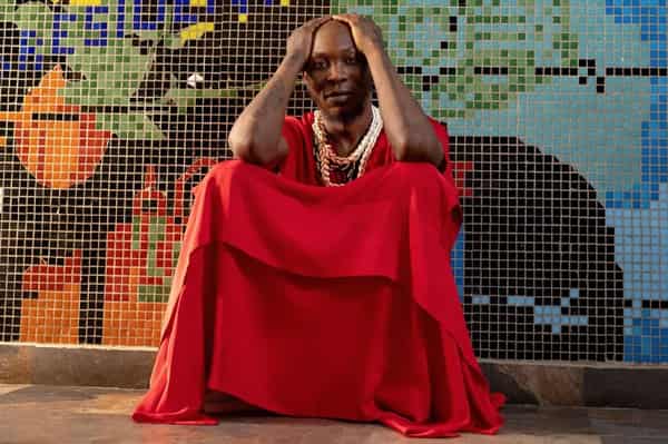 afrobeat-icon-seun-kuti-sits-with-his-hand-on-his-head-wearing-red