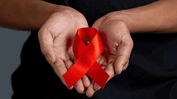 Woman hand holding red ribbon HIV awareness concept World AIDS Day and World Sexual Health Day