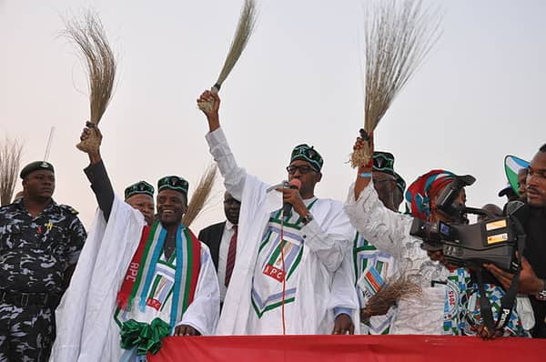 General_Buhari_holding_a_broom_at_a_campign_rally