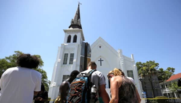Mourners pay their respects outside Emanuel African Methodist Episcopal Church after the street was re-opened a day after a mass shooting left nine dead during a bible study at the church in Charleston