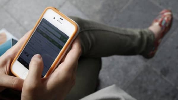 125295-a-woman-uses-her-apple-iphone-4-smartphone-for-web-surfing-during-a-ph-658×372