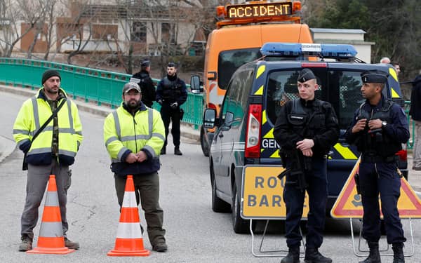 Gendarmes block the road near the site where two French military helicopters belonging to an army flight training school crashed killing five people near the Lac de Carces