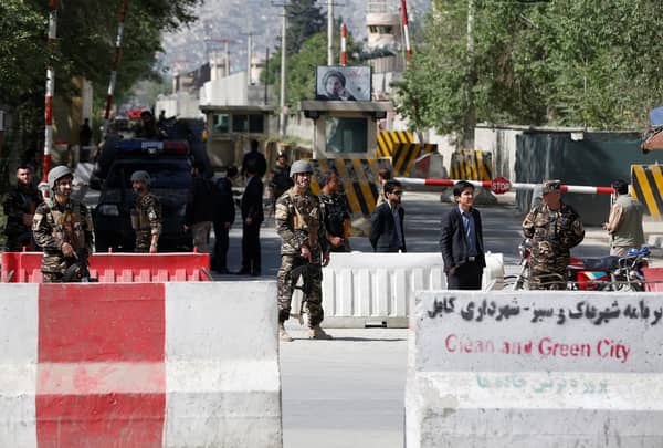 Afghan security forces stand guard near the site of a blast in Kabul, Afghanistan