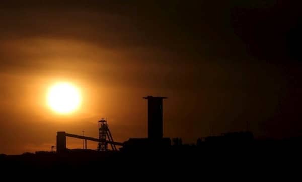 FILE PHOTO: The sun sets behind a shaft outside the mining town of Carletonville, west of Johannesburg