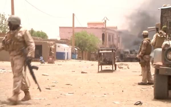 A still image taken from a video shows soldiers standing guard as smoke rises in the distance after a car bomb attack in Gao