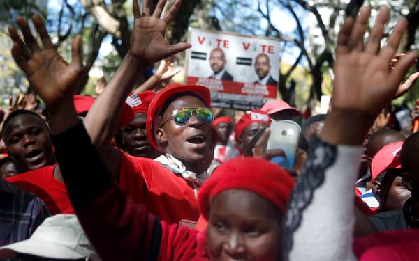 Members of Zimbabwe’s opposition parties hold placards during a march to the Zimbabwe Electoral Commission in Harare