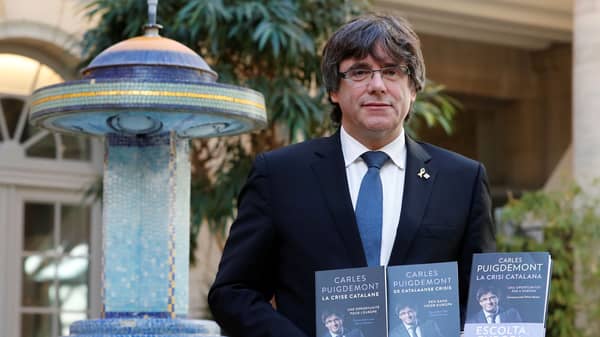 Former Catalan President Carles Puigdemont poses with the book “The Catalonia Crisis”  written with Belgian journalist Olivier Mounton, during presentation in Brussels