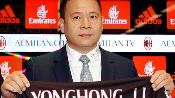 Yonghong Li shows a AC Milan jersey during a news conference in Milan