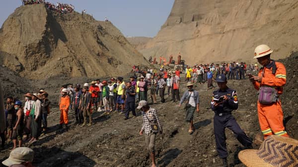 Local people look on in a jade mine where the mud dam collapsed in Hpakant