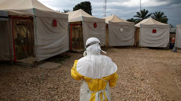 A health worker wearing Ebola protection gear, walks before entering the Biosecure Emergency Care Units at the Alima Ebola treatment centre in Beni