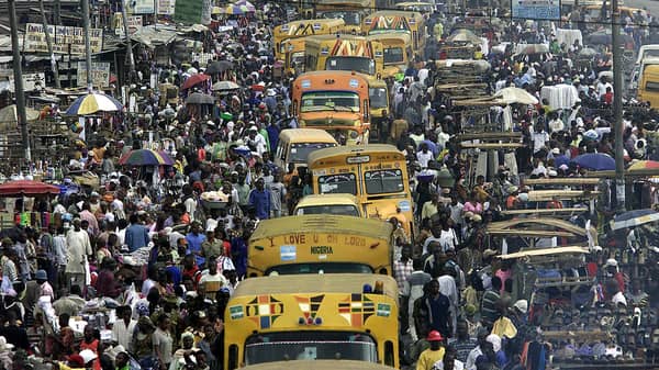 TRADERS AND COMMUTERS MOVE ON MAIN COMMERCIAL ROAD IN LAGOS.