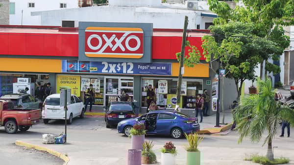 Cartel gunmen stand outside a store during clashes with federal forces following the detention of Ovidio Guzman, son of drug kingpin Joaquin “El Chapo” Guzman, in Culiacan