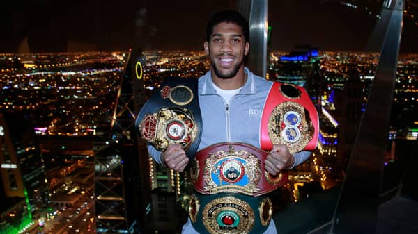 Anthony Joshua poses with the IBF, WBA, WBO & IBO World Heavyweight belts after winning his title fight against Andy Ruiz Jr