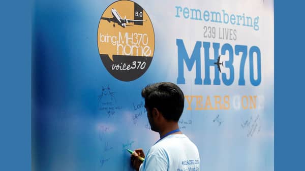 A man writes on a message board for passengers, onboard the missing Malaysia Airlines Flight MH370, during its fifth annual remembrance event in Kuala Lumpur