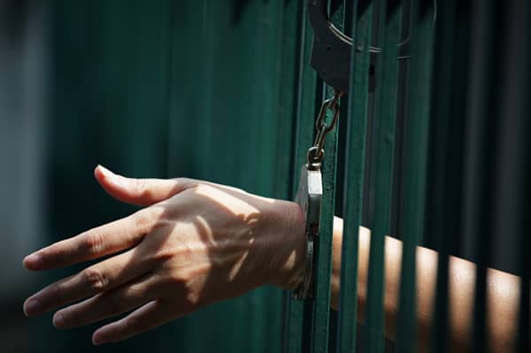 hand of prisoner locked with handcuff in jail