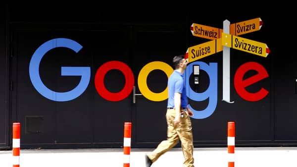 FILE PHOTO: A man walks past a logo of Google in Zurich
