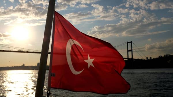 FILE PHOTO: A Turkish flag with the Bosphorus Bridge in the background flies on a passenger ferry in Istanbul