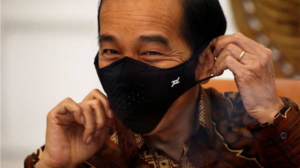 FILE PHOTO: Indonesian President Joko Widodo reacts as he wears a protective mask during an interview with Reuters at the Presidential Palace in Jakarta