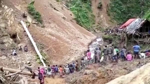 People gather on hillside after landslide in Saki