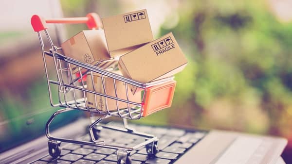 Online shopping and delivery service concept. Paper cartons in a shopping cart on a laptop keyboard, this image implies online shopping that customer order things from retailer sites via the internet.