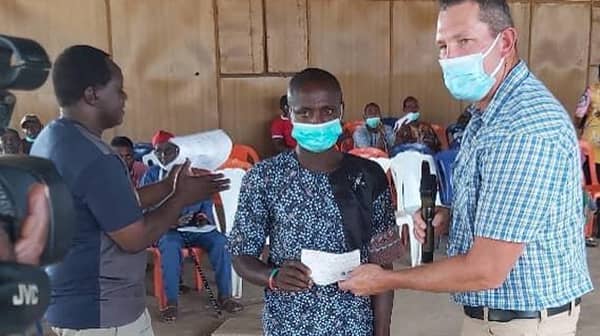 AgriPalm General Manager presenting a cheque to a compensated farmer