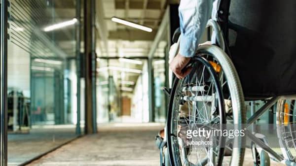 Paralyzed man in a wheelchair on the move in the disabled office building.