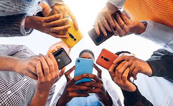 Teens,In,Circle,Holding,Smart,Mobile,Phones,-,Multicultural,Young