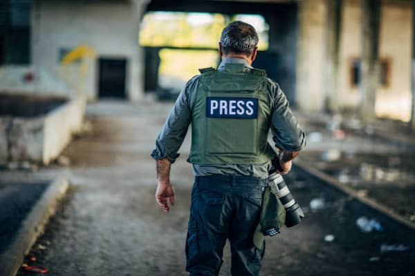 Mature journalist reporting from the war zone