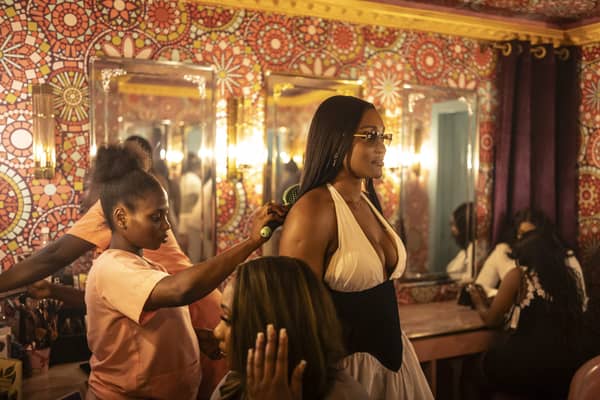 A worker combs a patron’s hair inside the restroom in the Boho nightclub during Detty December in Lagos