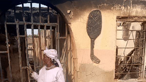 Olorisa in front of the burnt building