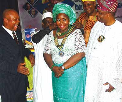 District Governor, Rotary International, District 9110 comprising Lagos and Ogun states, Otunba Bola Onabadejo (right), Immediate Past President, Rotary Club of Isolo, Rotarian Adegoke Adeoye, and r Abdullahi Asen Enakhume (left) and immediate past President, Hakeem Ibrahim decorating the in-coming President, Zainab Grace Enakhume. 